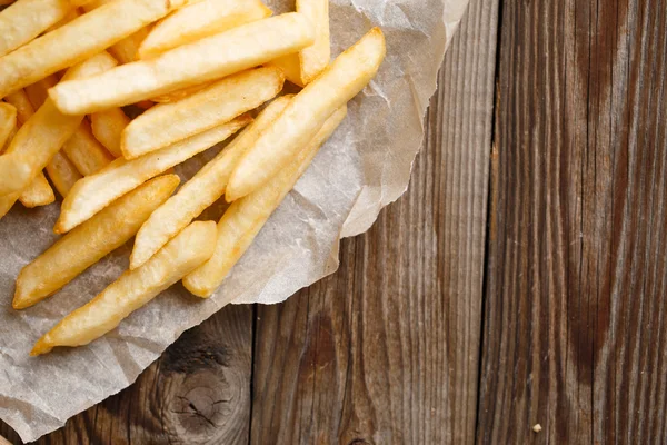 Papas fritas frescas sobre fondo de madera —  Fotos de Stock