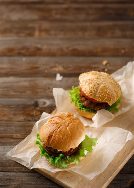 Домашние гамбургеры и картошка фри на деревянном столе — стоковое фото