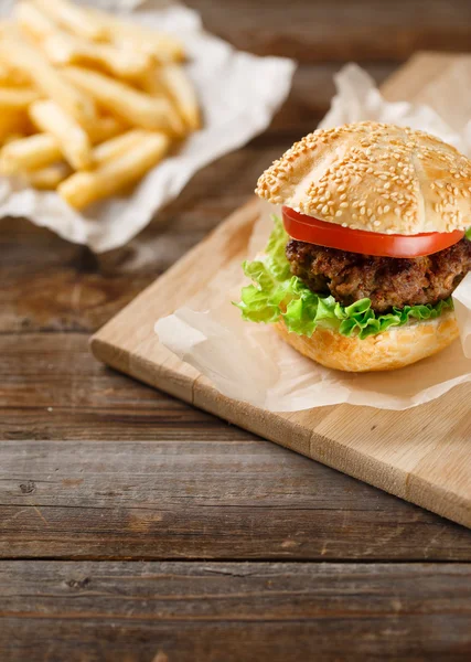 Homemade hamburgers and french fries on wooden table — Stock Photo, Image