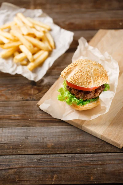 Homemade hamburgers and french fries on wooden table — Stock Photo, Image