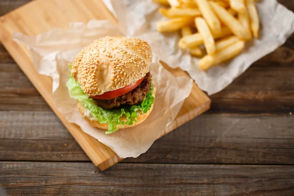 Homemade hamburgers and french fries on wooden table — Stock Photo, Image