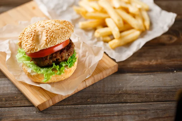 Domowe hamburgery i frytki na drewnianym stole — Zdjęcie stockowe