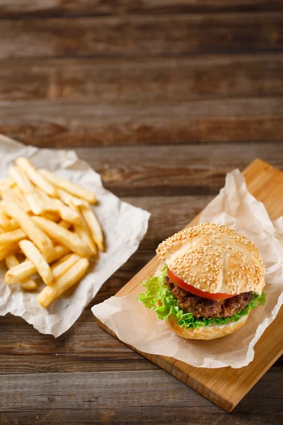 Homemade hamburgers and french fries on wooden table — Stock Photo, Image