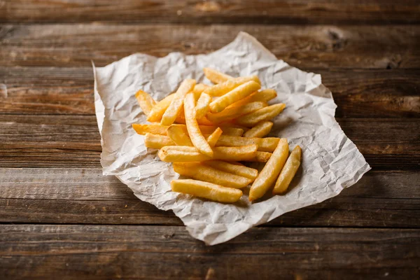 Papas fritas sobre mesa de madera. —  Fotos de Stock