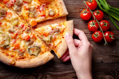 El malzeme çekme lezzetli dilim pizza ahşap masanın üzerinde yatan