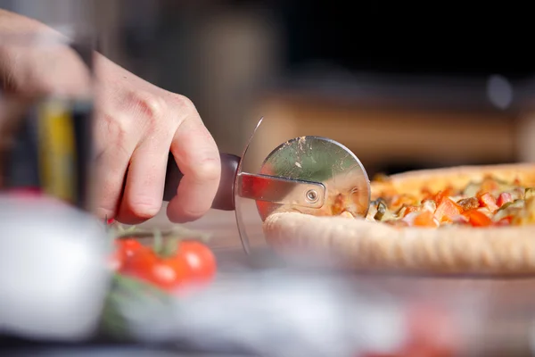 ローラー ナイフでスライス新鮮なピザ. — ストック写真