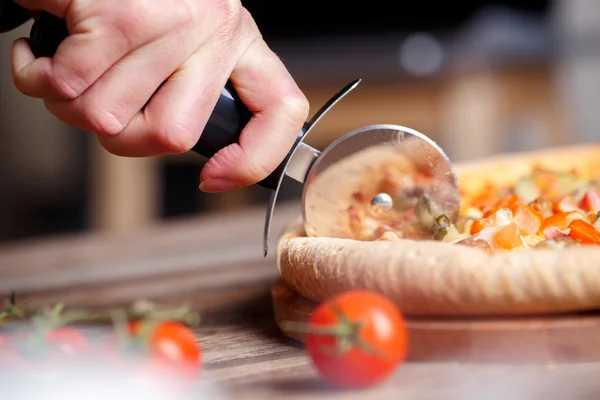 Cortar pizza fresca con cuchillo de rodillo . — Foto de Stock