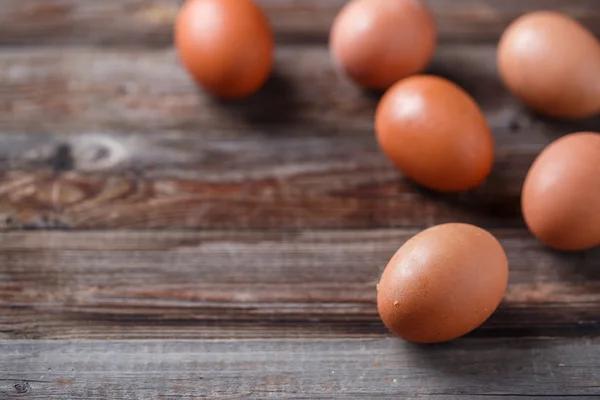 Braune Eier auf einem rustikalen Holztisch — Stockfoto