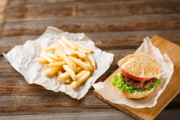 Domowe hamburgery i frytki na drewnianym stole — Zdjęcie stockowe
