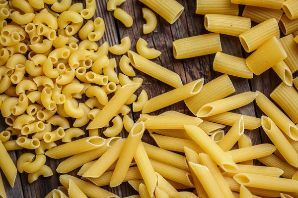 Nahaufnahme Porträt roher hausgemachter italienischer Pasta, Makkaroni, Spaghetti und Fettuccine — Stockfoto