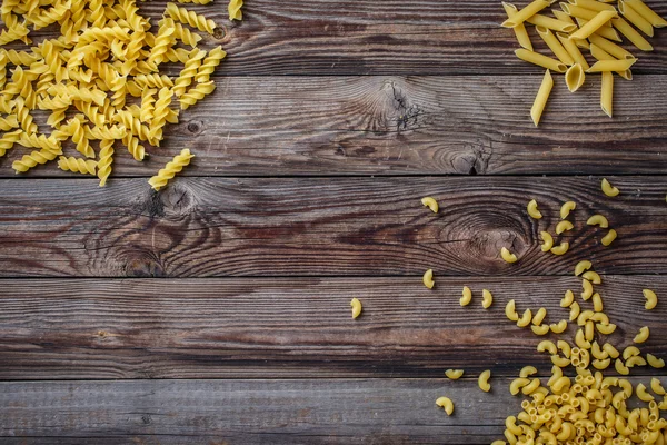Mixed dried pasta selection on wooden background. — Stock Photo, Image