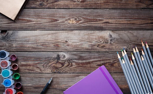 Acuarelas, lápices de colores y cuaderno de bocetos sobre mesa de madera. Flat lay foto con espacio vacío para el logo, texto. —  Fotos de Stock