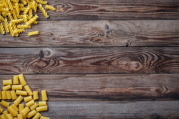 Mixed dried pasta selection on wooden background. — Stock Photo, Image