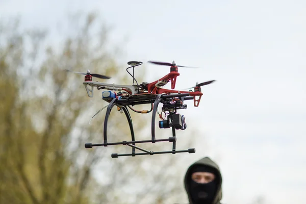 Homem mascarado operando um drone com controle remoto. — Fotografia de Stock