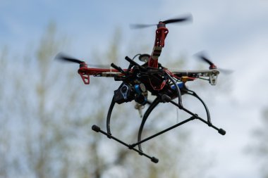 Gökyüzünde kamera olan uçan bir dron.