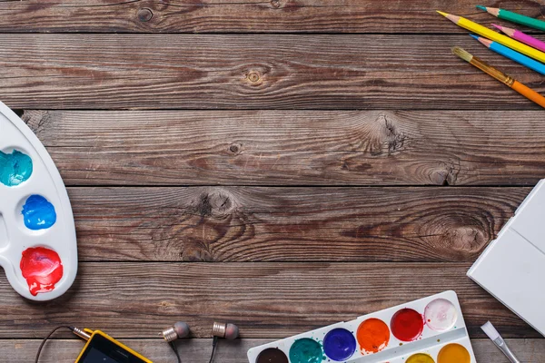 Papel, aquarelas, pincel de pintura e algumas coisas de arte na mesa de madeira — Fotografia de Stock