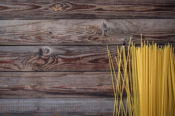 Lunghi spaghetti gialli su fondo nero. Spaghetti crudi. — Foto Stock