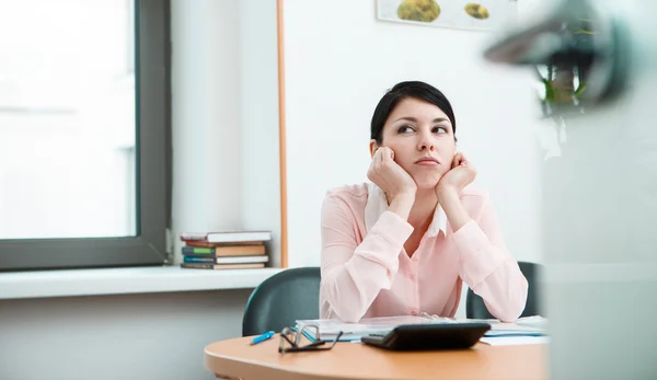 Junge Büroangestellte träumt an ihrem Arbeitsplatz — Stockfoto