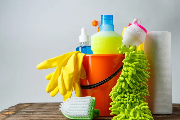 Balde com itens de limpeza em fundo claro — Fotografia de Stock