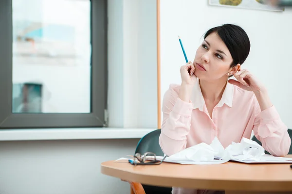 Mujer de negocios sentada en el escritorio en la oficina con pensamientos. —  Fotos de Stock