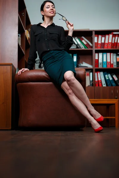 Женщина с флиртом позирует в офисе . — стоковое фото