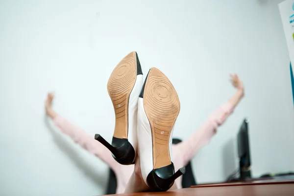 Relaxado mulher de negócios sentado em uma cadeira com pernas sobre a mesa. — Fotografia de Stock