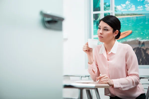 Vrouw koffie drinken in office keuken — Stockfoto