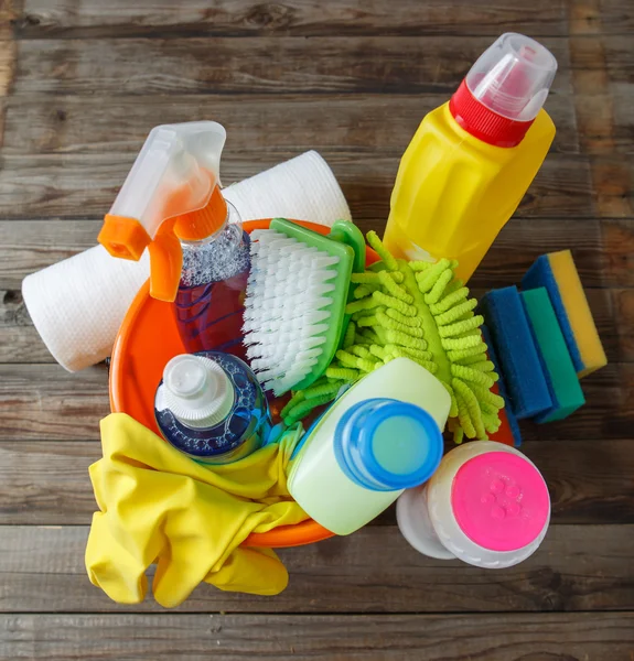 Plastic bucket with cleaning supplies on wood background — Stock Photo, Image