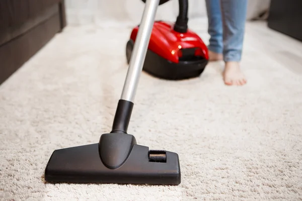 Mujer haciendo limpieza en la habitación, aspirando alfombra blanca —  Fotos de Stock