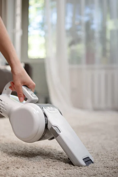 Mujer limpieza alfombra inalámbrico aspiradora de mano — Foto de Stock