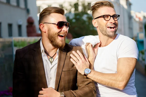 Dos elegantes hombres barbudos sonrientes en el fondo de la calle —  Fotos de Stock