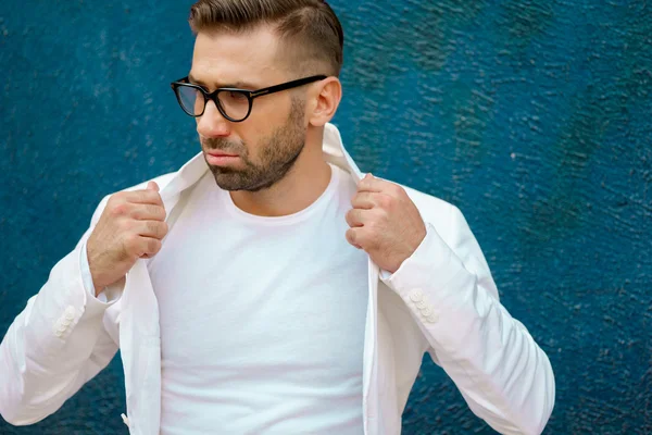 Modemann mit Brille passt seine weiße Jacke an — Stockfoto