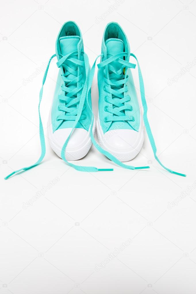Pair of shoes with long laces untied in white background