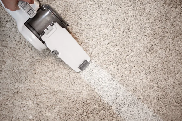 Top view of cordless handheld vacuum cleaner on beige carpet — Stock Photo, Image
