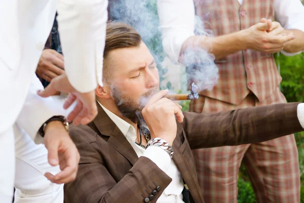 Elegante bel ragazzo godendo di sigaretta con gli amici — Foto Stock