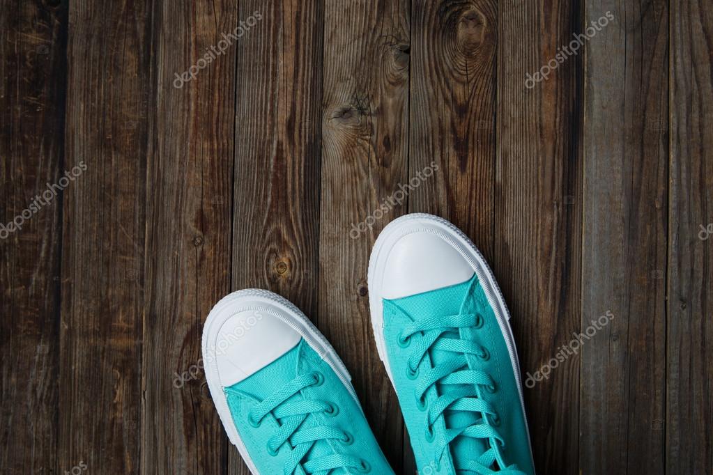 Shoes with laces over empty wooden floor