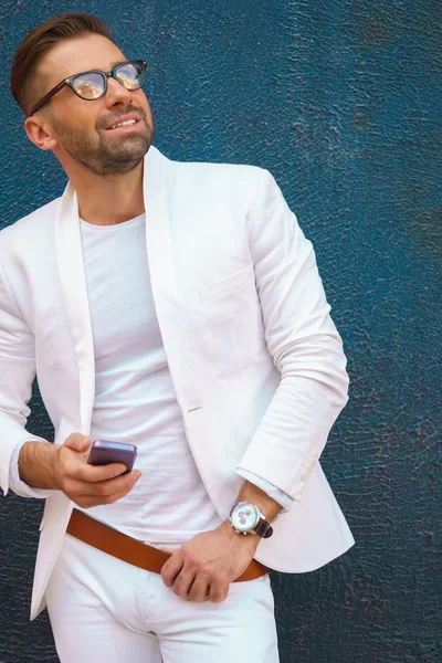 Стильный портрет человека в белом костюме с телефоном — стоковое фото