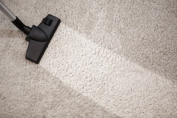 Cabeza de aspiradora en alfombra polvorienta y tira limpia — Foto de Stock
