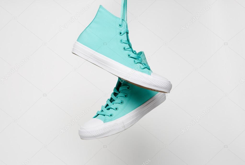 Blue shoes hanging on laces isolated on white background