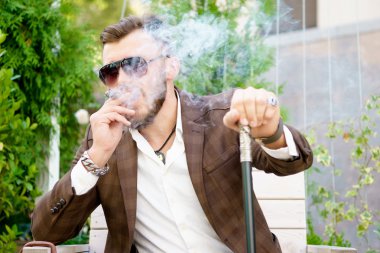 Şık takım elbise smokinga puro Park moda yakışıklı adam