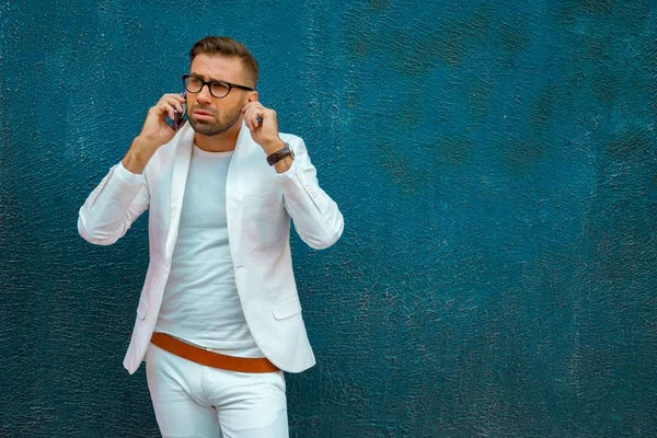 Moderno giovane ragazzo alla moda in occhiali che parla al telefono — Foto Stock