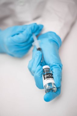 Doktor aşıyı şırıngaya çeviriyor.