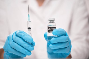 Mavi eldivenli doktorun elinde Coronavirus aşısı konsepti