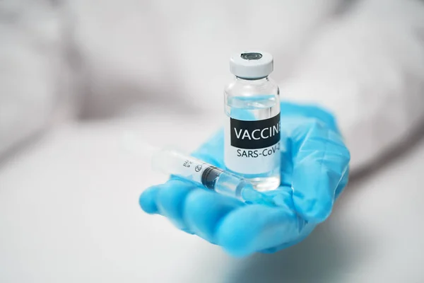 Coronavirus Concept de vaccin en main du médecin avec des gants bleus — Photo
