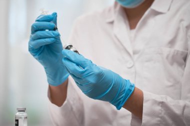 Mavi eldivenli doktorun elinde Coronavirus aşısı konsepti