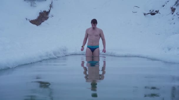 Junger Mann schwimmt im Winterfluss — Stockvideo