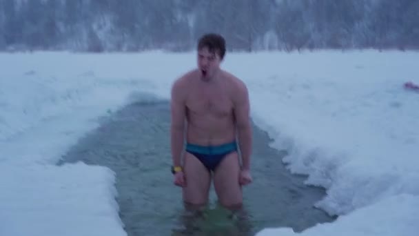 Junger Mann schwimmt im Winterfluss — Stockvideo