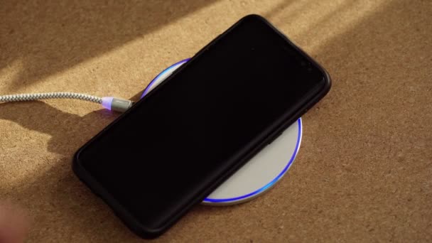 Jemand steckte Smartphone an drahtloses Ladegerät. — Stockvideo