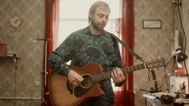 Mann spielt Gitarre und spricht — Stockvideo