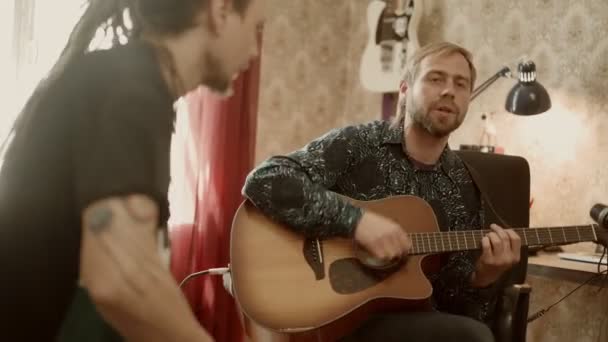 Mann spielt Gitarre und singt neben Freund — Stockvideo